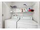 Bright laundry room with washer, dryer, and shelving for storage at 6514 Thicket Trl, New Port Richey, FL 34653