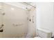 A bathroom shower stall with tile surround, shower head, grab bar, and tiled floor at 6514 Thicket Trl, New Port Richey, FL 34653
