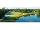 Scenic aerial view of a lush golf course alongside a tranquil lake with mature trees at 6534 Fairway Gardens Dr # 17-201, Bradenton, FL 34203