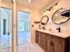 Bathroom boasts a double vanity, modern lighting, and access to a bedroom with a balcony at 6534 Fairway Gardens Dr # 17-201, Bradenton, FL 34203