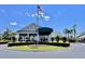 Beautiful clubhouse entrance with manicured landscaping and American flag at 6534 Fairway Gardens Dr # 17-201, Bradenton, FL 34203