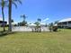 Community pool area surrounded by lush green grass and palm trees at 6534 Fairway Gardens Dr # 17-201, Bradenton, FL 34203