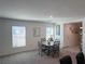 Bright dining area with a glass-top table and seating for four near two windows with blinds at 7530 Broad Pointe Dr, Zephyrhills, FL 33540