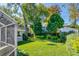 Expansive backyard with a lush lawn, mature trees, and partially fenced perimeter at 827 S Delaware Ave, Tampa, FL 33606