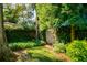 Picturesque backyard featuring a wooden gate nestled amidst lush greenery and mature trees at 827 S Delaware Ave, Tampa, FL 33606