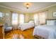 Inviting bedroom with two twin beds, bright windows, and beautiful hardwood floors at 827 S Delaware Ave, Tampa, FL 33606