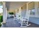 Inviting covered front porch with rocking chairs and hanging planters, perfect for relaxing at 827 S Delaware Ave, Tampa, FL 33606