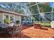 Covered patio featuring brick floors, outdoor furniture, and views of the lush backyard at 827 S Delaware Ave, Tampa, FL 33606