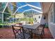 Enclosed patio with brick flooring, seating, and view of the well maintained backyard at 827 S Delaware Ave, Tampa, FL 33606