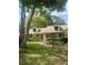 Charming single-story home with dormer windows, a lush lawn, mature trees, and well-maintained landscaping at 8361 Cofield Ln, Spring Hill, FL 34608