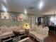 Cozy living room boasts hardwood floors, floral decorations, and comfortable ornate sofas at 8361 Cofield Ln, Spring Hill, FL 34608