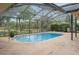 Inviting pool with a screened-in enclosure and scenic backyard views at 8361 Cofield Ln, Spring Hill, FL 34608