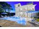 A stunning three-story home featuring a pool with lounge chairs, and an outdoor living area, set against a dusk sky at 885 Seaview Cir # 20, Crystal Beach, FL 34681