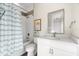 Bright bathroom features a shower-tub combination with blue striped curtain and white vanity at 885 Seaview Cir # 20, Crystal Beach, FL 34681