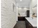 Elegant bathroom featuring stone accent wall, double vanity with white countertop, and tile flooring at 885 Seaview Cir # 20, Crystal Beach, FL 34681