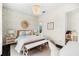 Stylish bedroom with a tropical accent wall, rattan mirror, chandelier, and light neutral color scheme at 885 Seaview Cir # 20, Crystal Beach, FL 34681