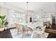 Bright dining room with a white table, stylish chairs, modern light fixtures, and an adjacent kitchen at 885 Seaview Cir # 20, Crystal Beach, FL 34681