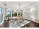 Bright dining room features a white table, stylish chairs, modern light fixtures, and large windows at 885 Seaview Cir # 20, Crystal Beach, FL 34681