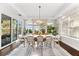 Bright dining room with large windows, modern light fixture, a white table and comfortable chairs at 885 Seaview Cir # 20, Crystal Beach, FL 34681