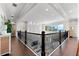 Open hallway overlooking great room and waterfront views, features dark wood floors and iron railing at 885 Seaview Cir # 20, Crystal Beach, FL 34681