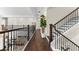 Upstairs landing with wood floors, wrought iron railing and view to downstairs at 885 Seaview Cir # 20, Crystal Beach, FL 34681