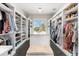 Large walk-in closet features custom shelving, storage and center island with bench at 885 Seaview Cir # 20, Crystal Beach, FL 34681