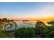 Scenic water view at sunset with trees in foreground and a pier in the distance at 885 Seaview Cir # 20, Crystal Beach, FL 34681