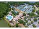 Aerial view of the community clubhouse, pool, multiple tennis courts, and surrounding greenery at 9315 Knightsbridge Ct, Tampa, FL 33647