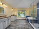 Bright bathroom featuring a glass shower, a soaking tub, and double vanities at 9315 Knightsbridge Ct, Tampa, FL 33647