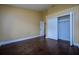 Bedroom featuring hardwood floors, base trim, yellow walls, and a closet with double doors at 9315 Knightsbridge Ct, Tampa, FL 33647