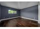 Spacious bedroom with dark hardwood flooring and natural light from a window at 9315 Knightsbridge Ct, Tampa, FL 33647