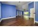 Spacious bedroom with hardwood floors, blue walls, base trim, and multiple entry points at 9315 Knightsbridge Ct, Tampa, FL 33647