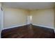 Empty bedroom boasts hardwood floors, yellow walls, baseboards, and open door to bath at 9315 Knightsbridge Ct, Tampa, FL 33647