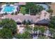 Aerial shot of a clubhouse with a pool, mini golf, tennis court, and playground, surrounded by lush landscaping at 9315 Knightsbridge Ct, Tampa, FL 33647