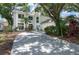 Stately two-story home featuring stucco exterior, manicured landscaping, and a circular driveway at 9315 Knightsbridge Ct, Tampa, FL 33647
