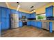 Bright kitchen featuring custom blue cabinets, stainless steel appliances, and granite countertops at 9315 Knightsbridge Ct, Tampa, FL 33647