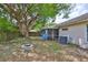 View of the home's backyard including stone firepit and screened patio at 1005 Hardwood Dr, Valrico, FL 33596