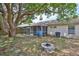 View of the home's backyard including stone firepit and screened patio at 1005 Hardwood Dr, Valrico, FL 33596