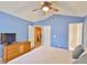 Bedroom featuring blue walls, a ceiling fan, wood furniture, and an ensuite bathroom at 1005 Hardwood Dr, Valrico, FL 33596