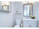 Bathroom with a decorative mirror, granite countertop, white cabinets, and toilet at 1015 Seagrape Dr, Ruskin, FL 33570