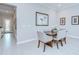 Cozy dining area featuring a wooden table, upholstered chairs, elegant artwork, and access to the front entry at 1015 Seagrape Dr, Ruskin, FL 33570