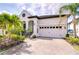 Stunning home featuring a beautiful brick driveway, attached two-car garage, and lush tropical landscaping at 1015 Seagrape Dr, Ruskin, FL 33570