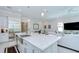 Spacious kitchen features a large island with sink, stainless steel refrigerator, and flows into the living and dining areas at 1015 Seagrape Dr, Ruskin, FL 33570