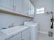 Laundry room with white cabinets, countertop, sink, and a new washer and dryer at 1015 Seagrape Dr, Ruskin, FL 33570
