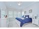 A traditional primary bedroom featuring a blue bed, two windows and a dresser at 1015 Seagrape Dr, Ruskin, FL 33570