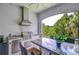 Outdoor kitchen area equipped with a grill, counter space, and a stainless steel refrigerator at 1015 Seagrape Dr, Ruskin, FL 33570
