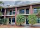 Two-story building featuring brick and tan exterior, black railings, and tropical landscaping in front at 1020 85Th N Ave # 222, St Petersburg, FL 33702
