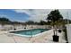 Refreshing outdoor pool with a clean deck, surrounded by a white fence and lush greenery at 1020 85Th N Ave # 222, St Petersburg, FL 33702