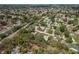 Expansive aerial view of a community surrounded by lush greenery and a small lake at 10516 Mira Vista Dr, Port Richey, FL 34668