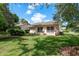 Exterior shot of the back of the house with a lawn, lush landscaping, and window awnings at 10516 Mira Vista Dr, Port Richey, FL 34668